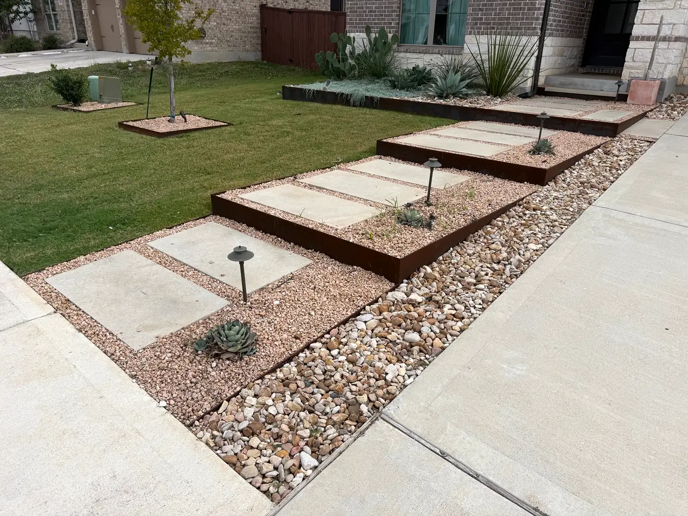 Stepped pads in steel-edged gravel beds along a driveway