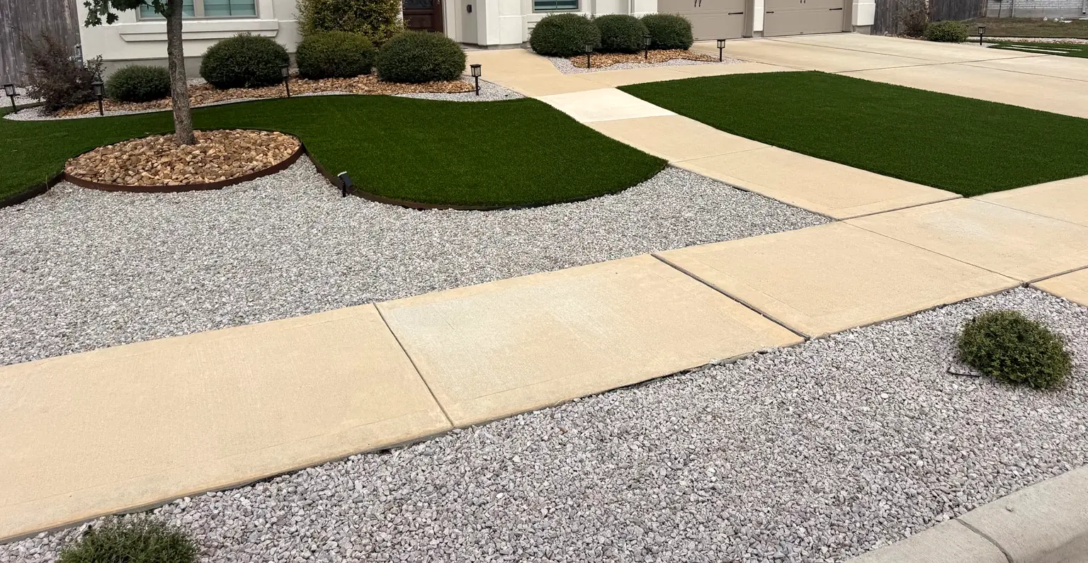 Curved artificial turf areas framed by gravel, with a mulched tree ring