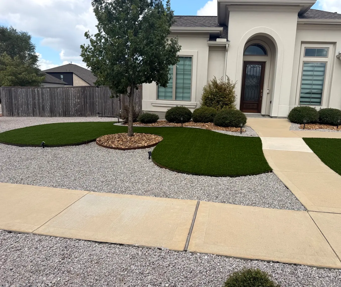 Curved artificial turf area beside the front walk